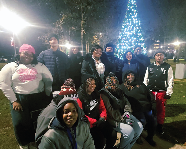 Family smiles as tree is lit.