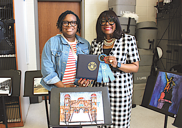 Rep. Sewell poses with Mrs. Kaysha Moore Davis, art teacher at Paul W. Bryant
High School in Tuscaloosa, alongside the winning submission