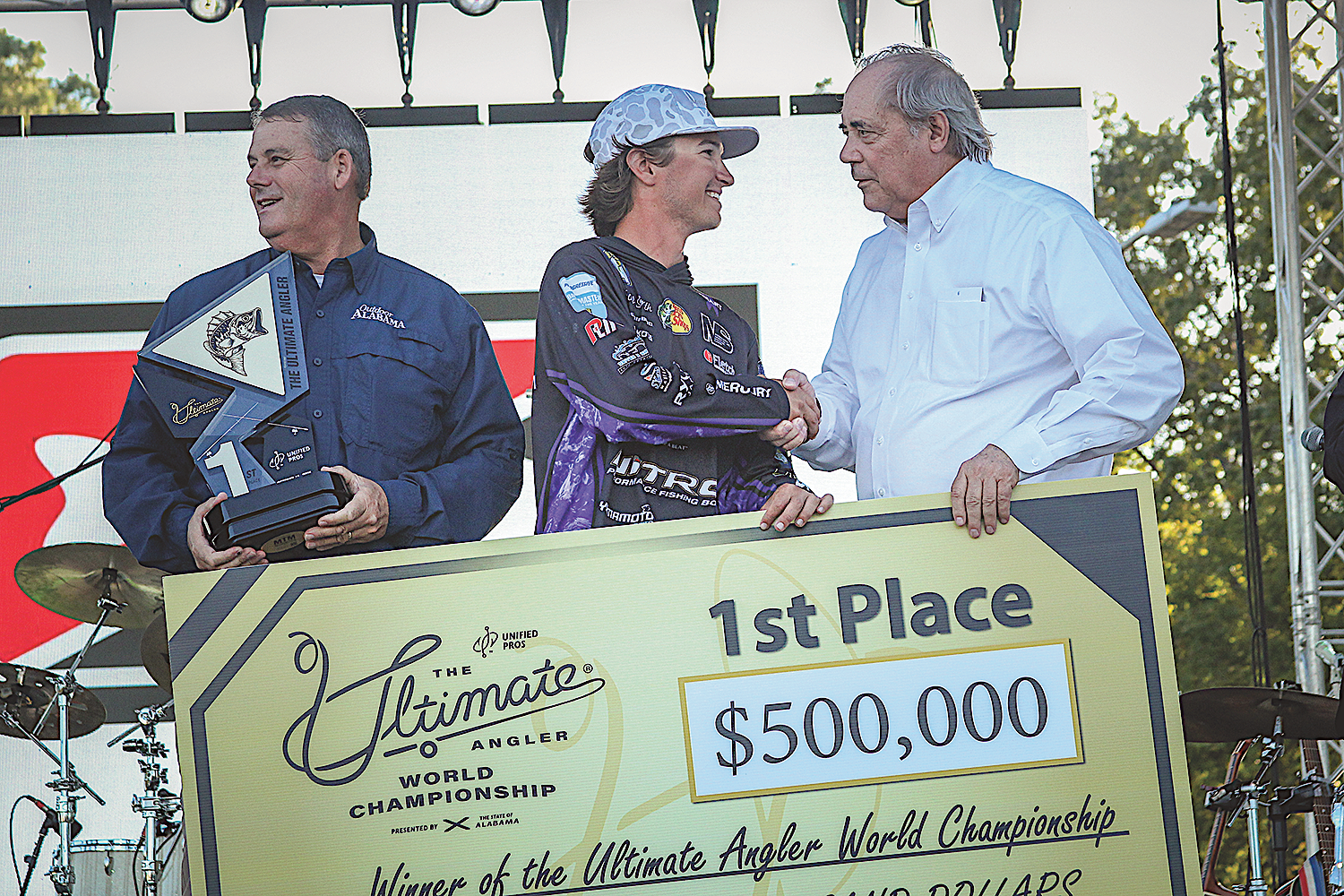 Conservation Commissioner Chris Blankenship holds the trophy as Tucker Smith is congratulated by Senator Steve Livingston for winning the Ultimate Angler Championship at Lake Guntersville. Photos by Kate Stone, Billy Pope, David Rainer