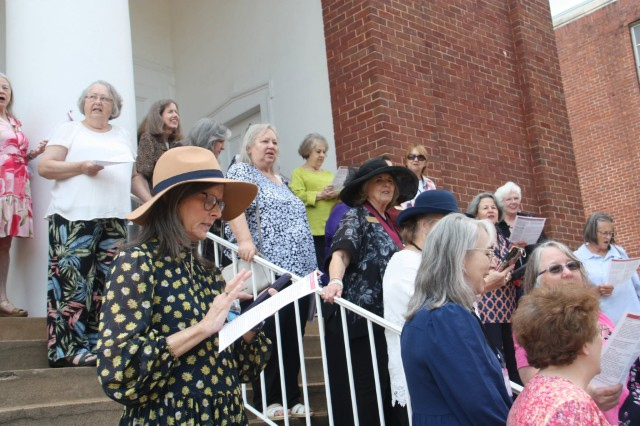 Judson College women on the steps of Siloam Baptist Church singing traditional step-sing songs